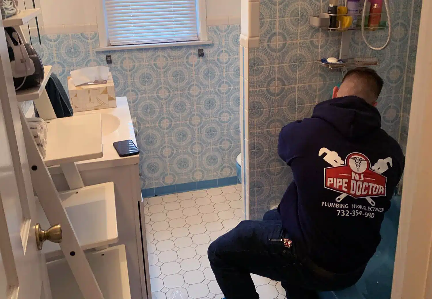 Image of NJ Pipe Dr plumber in Rahway working on drains in a bathroom