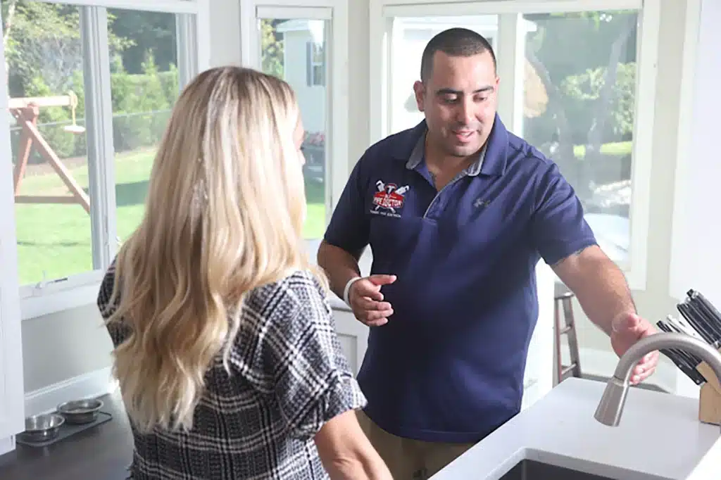 Image of NJ Pipe Dr plumber and HVAC tech in New Providence talking to a client in her home